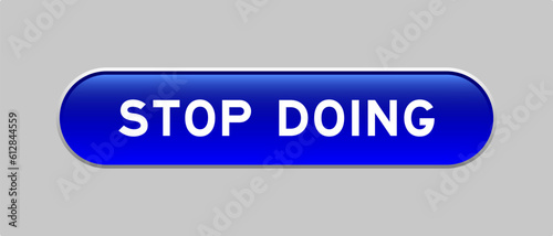 Blue color capsule shape button with word stop doin on gray background