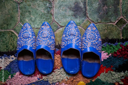 Moroccan handicraft. Traditional babouche leather slippers on ornamental Moroccan wool rug.