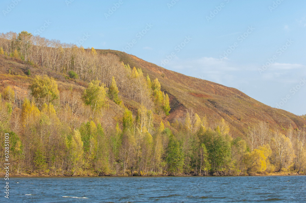 Photo of an autumn landscape, an almost perfect reflection of the Rocky Mountains in the Kama River. Near Kazan, Tatarstan, Russia. The winter season is approaching. Country of bears.