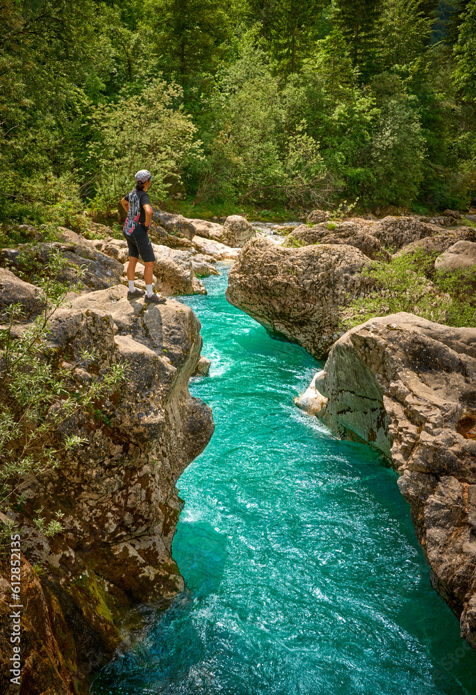 woman resting during a hiking tour along turquoise River Soca in the Triglav National Park of the Julian Alps in Slovenia