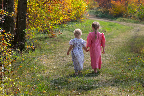 Mennonite sisters holding hands walking