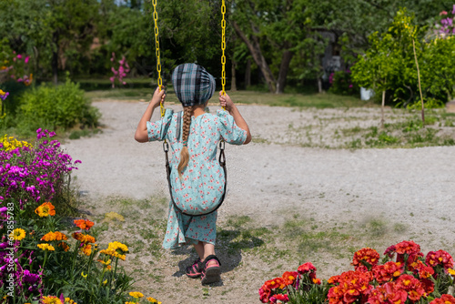 Mennonite child's back on swing in the playground 