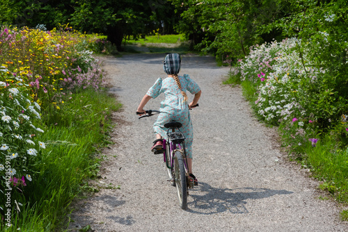 Young Mennonite girl on bicycle down the path