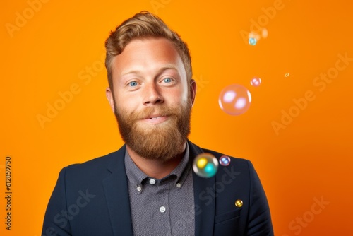 Headshot portrait photography of a happy boy in his 30s blowing bubbles against a bright orange background. With generative AI technology