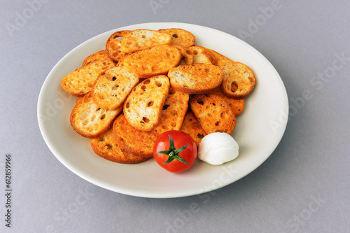 Toasted bread slices with tomatoes and mozzarella on a gray background © fotosenukas