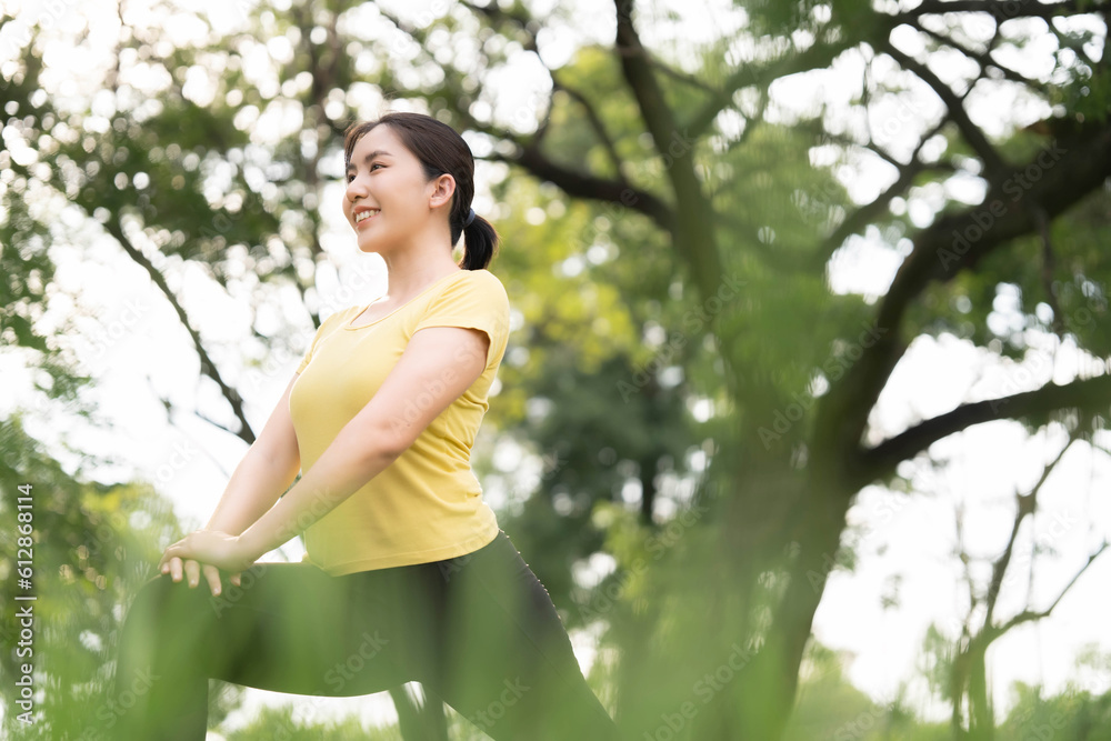 Asian woman stretching at the park before exercising. health care concept Stretching to warm up the muscles before going for a run. Asian woman stretching at the park before exercising. health care concept Stretching to warm up the muscles before going for a run.