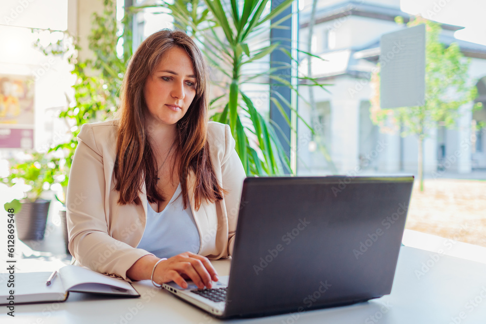 Young female teacher getting ready for lesson working in office using laptop. Woman typing. Working online Young female teacher getting ready for lesson working in office using laptop. Woman typing. Working online