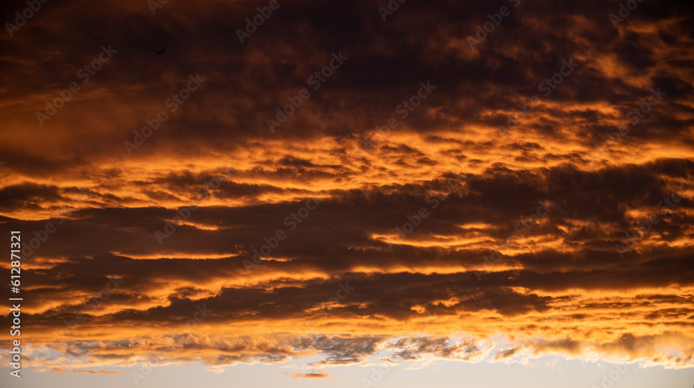 warm golden hour sky with bright orange yellow clouds. Ideal for sky replacement in modern photo editing software tools, beautiful evening atmosphere