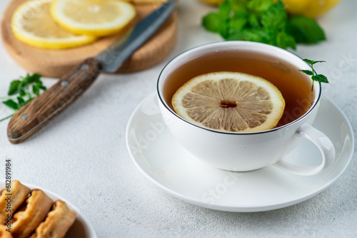 Tea with lemon in a white mug on the table