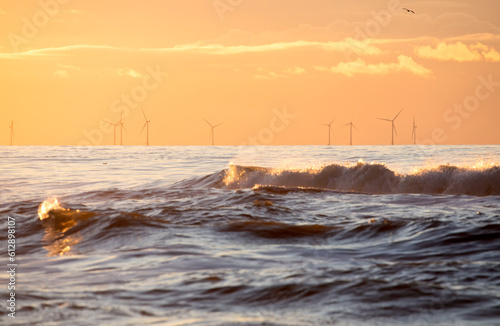 sea waves at susnet and windmills