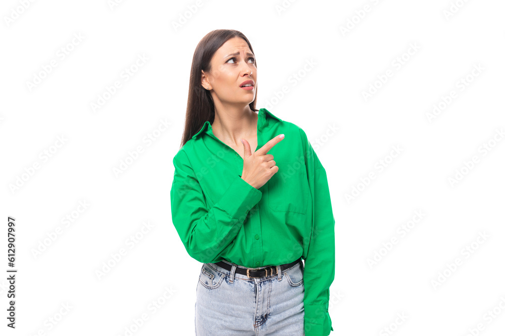 brown-eyed brunette young business lady in a green shirt shows her hand to the side on a white background with copy space brown-eyed brunette young business lady in a green shirt shows her hand to the side on a white background with copy space
