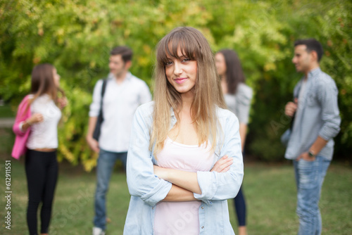 Outdoor portrait of a smiling young woman in front of a group of students