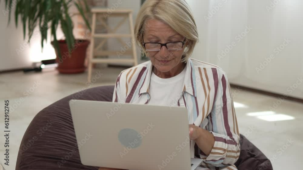 One mature caucasian blonde woman work use laptop computer One mature caucasian blonde woman work use laptop computer