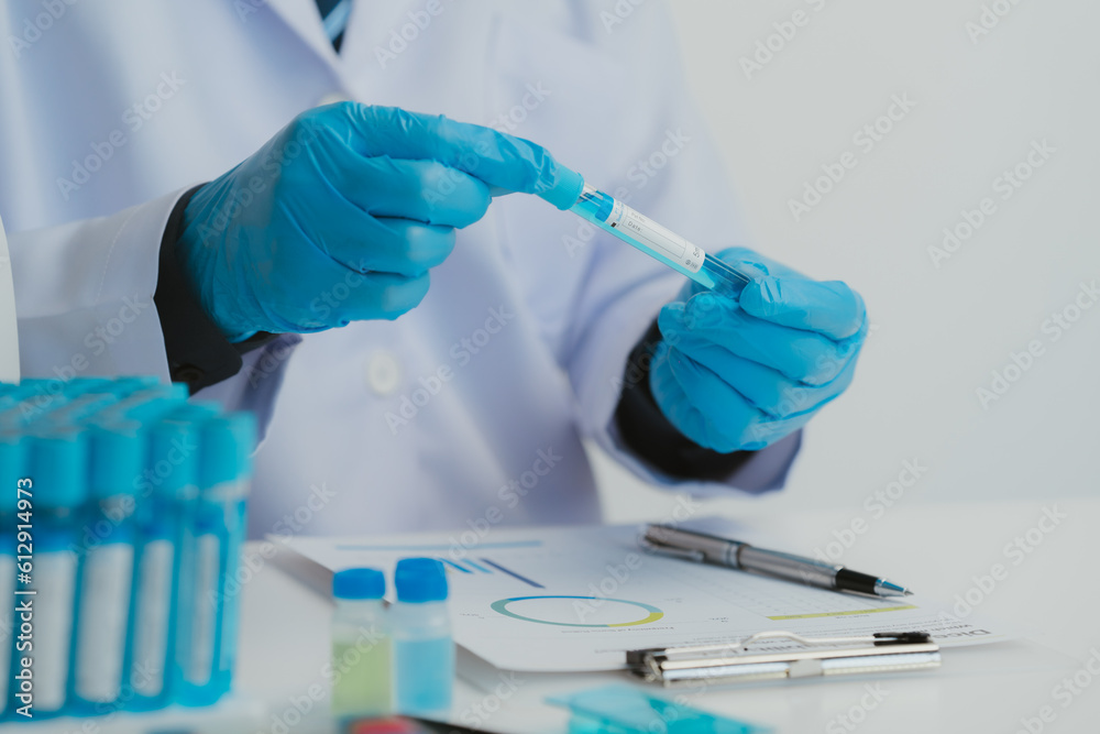 Close up view of scientist analyzing a liquid in the test tubes in laboratory. Close up view of scientist analyzing a liquid in the test tubes in laboratory.