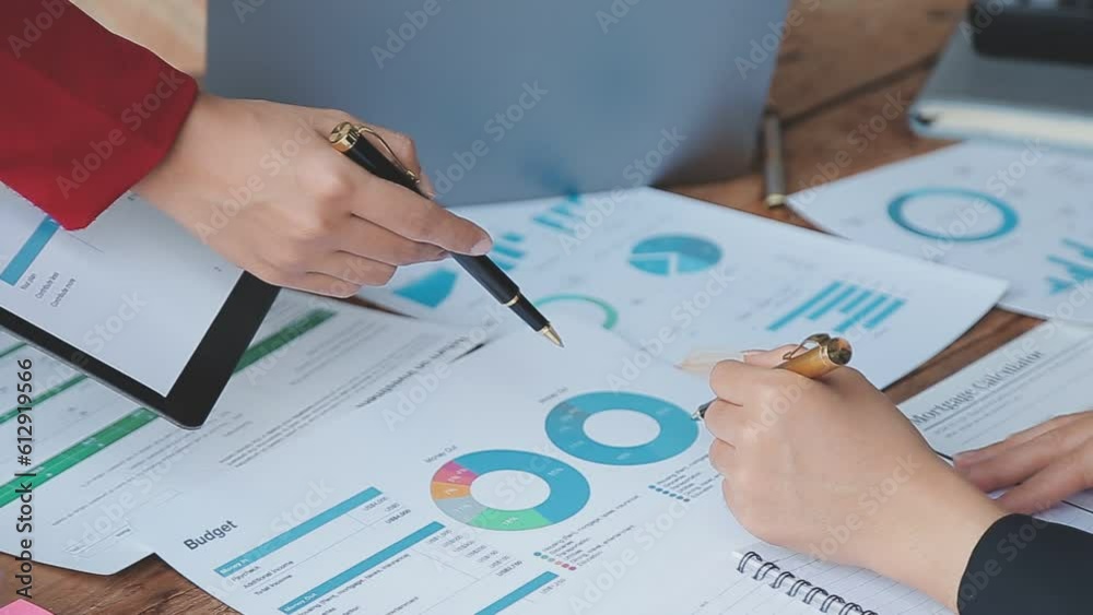 Financial analysts analyze business financial reports on a digital tablet planning investment project during a discussion at a meeting of corporate showing the results of their successful teamwork. Financial analysts analyze business financial reports on a digital tablet planning investment project during a discussion at a meeting of corporate showing the results of their successful teamwork.