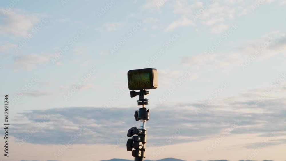 An action camera shoots a time lapse of the sky on the shore of the lake.