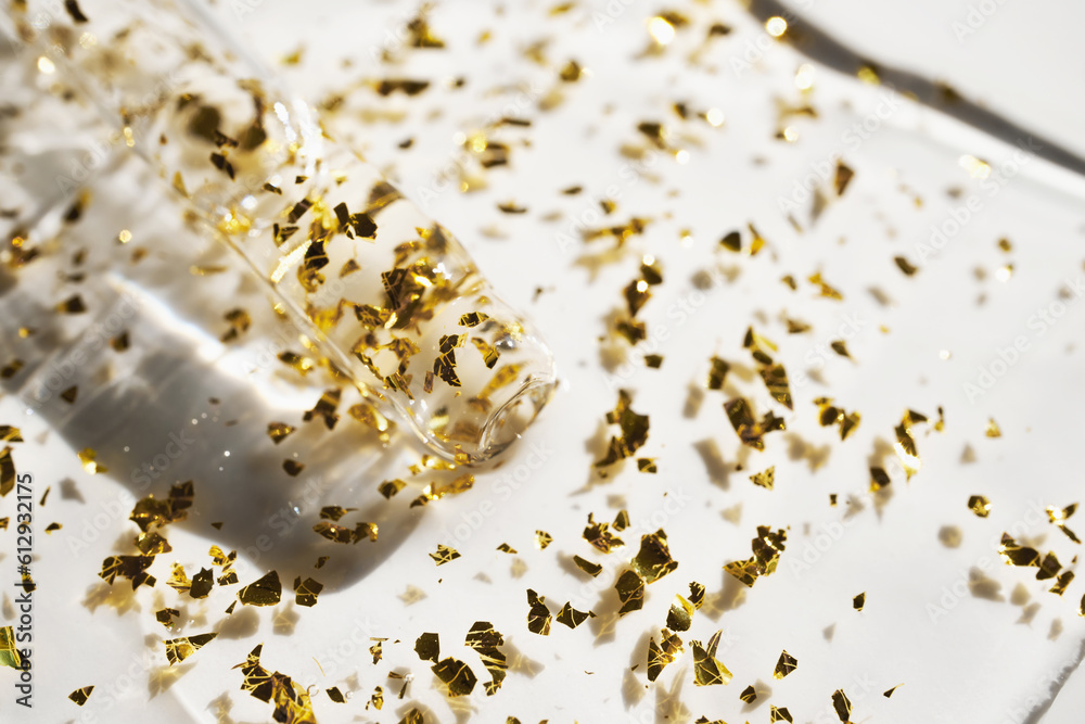 Pipette and drop of cosmetic product with gold particles, selective focus Pipette and drop of cosmetic product with gold particles, selective focus