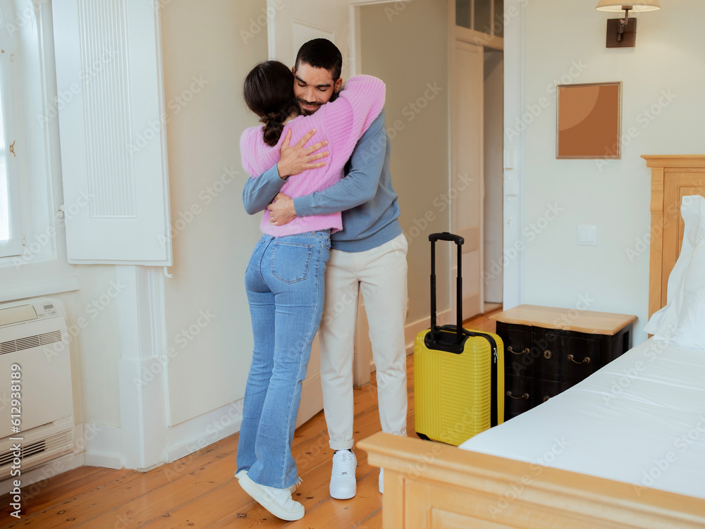 Loving Spouses Hugging Standing With Suitcase At Hotel Suite Interior Loving Spouses Hugging Standing With Suitcase At Hotel Suite Interior