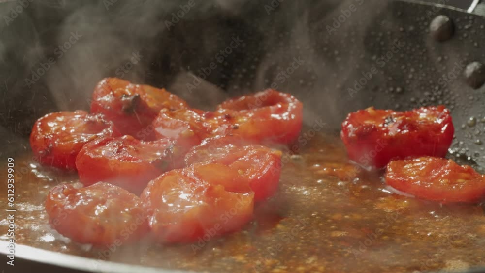Fresh cherry tomatoes in a frying pan with olive oil and spices. Cooking tomato sauce. Traditional Italian Mexican Asian dish. High quality studio shot for cafe, restaurant close up. Fresh cherry tomatoes in a frying pan with olive oil and spices. Cooking tomato sauce. Traditional Italian Mexican Asian dish. High quality studio shot for cafe, restaurant close up.