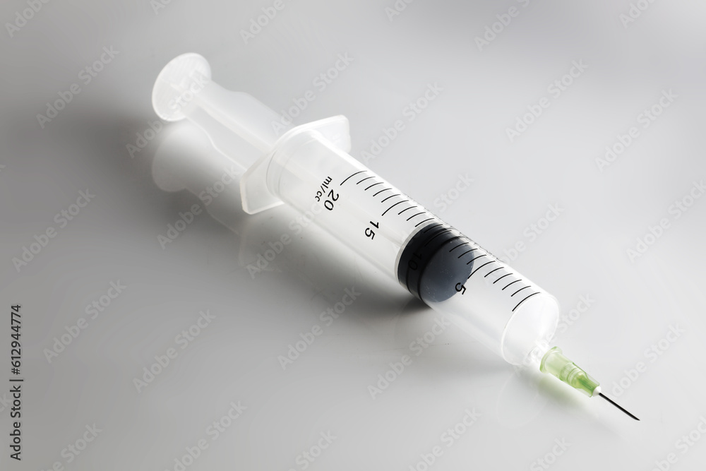 Syringe on white medical surface with shadow Syringe on white medical surface with shadow