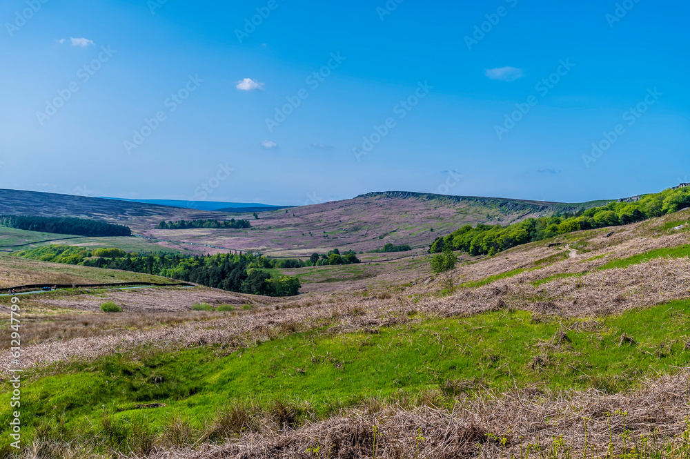 A view across the valley below the highest part of the Stanage Edge escarpment in the Peak District, UK in summertime A view across the valley below the highest part of the Stanage Edge escarpment in the Peak District, UK in summertime