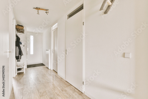 Vászonkép a long hallway with white walls and wood flooring the room is clean and ready fo
