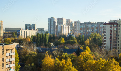 Panoramic urban landscape - multi-storey modern houses of Reutov in the Moscow region among the lush foliage of trees on a clear autumn morning and a space for copying