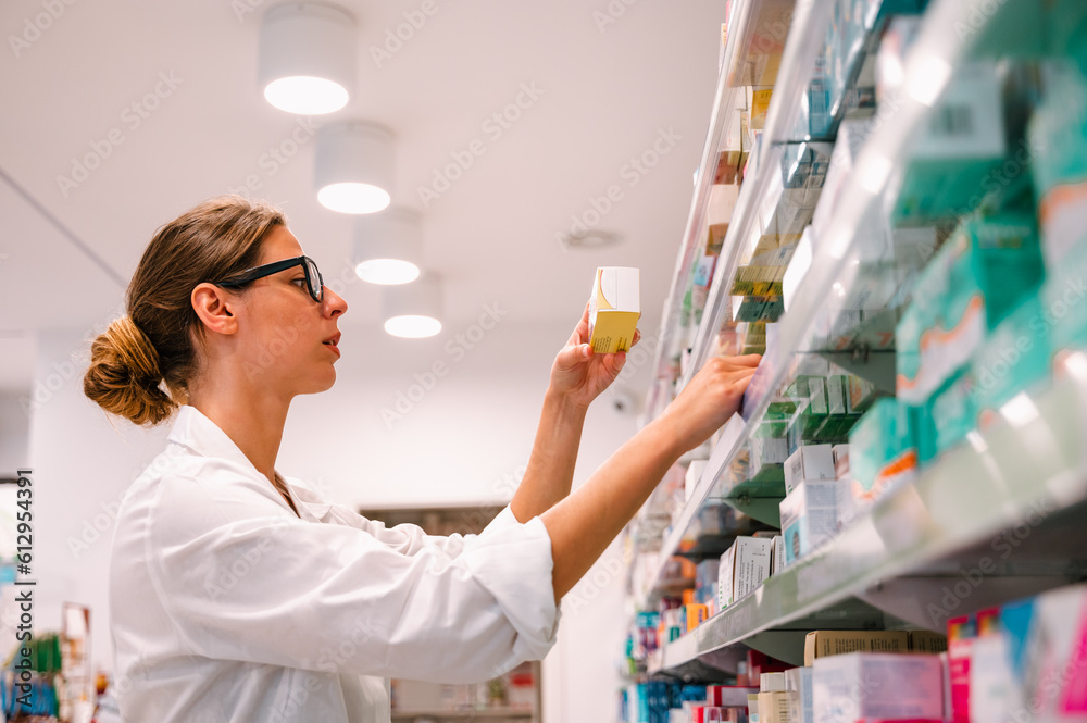 Woman working in the pharmacy looks for the medicine