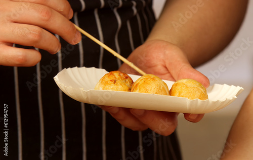 Cook at the stand of the Japanese Embassy is sticking a portion of deep-fried dumplings into a paper box for a customer to take home.