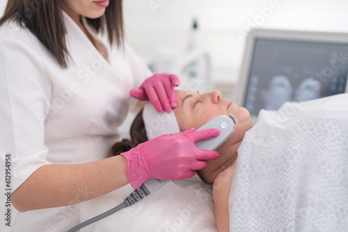 beauty center provides a relaxing environment for a female client to receive a SMAS ultrasound face lifting procedure using professional equipment.