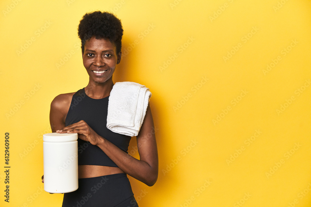 Naklejka premium African woman in sportswear with protein powder and towel