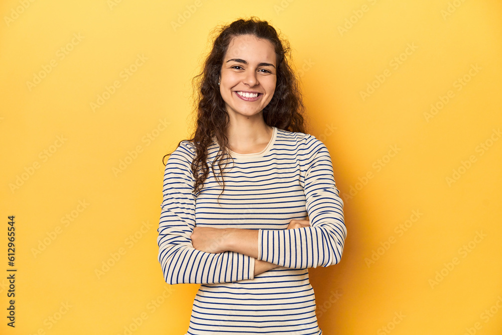 Obraz premium Young Caucasian woman, yellow studio background, who feels confident, crossing arms with determination.