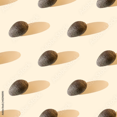 Avocado on beige pastel background with long shadows. Seamless pattern