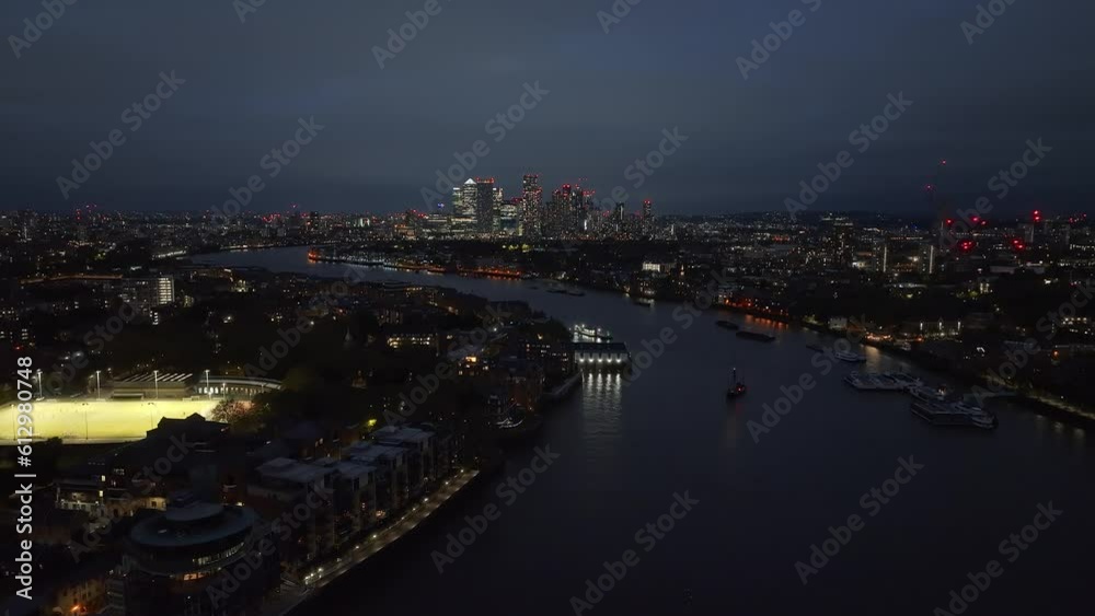 Beautiful night panoramic view of London Thames river with Canary Wharf skyline in the background. Beautiful London district at night. Beautiful night panoramic view of London Thames river with Canary Wharf skyline in the background. Beautiful London district at night.
