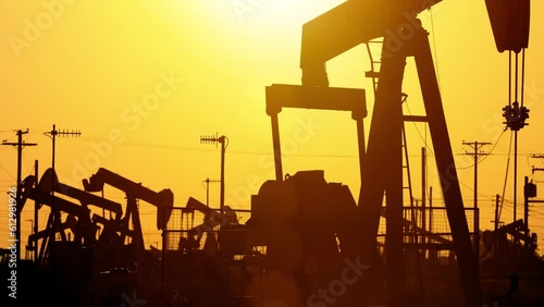 The sun rises behind oil pumps in California