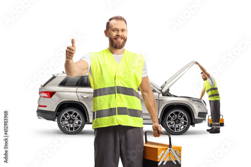 Roadside assistance compay workers checking a SUV and gesturing thumbs up photo