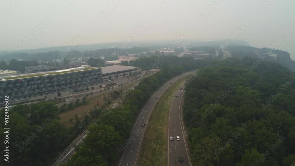 Foggy sky over cars on highway and forest Foggy sky over cars on highway and forest