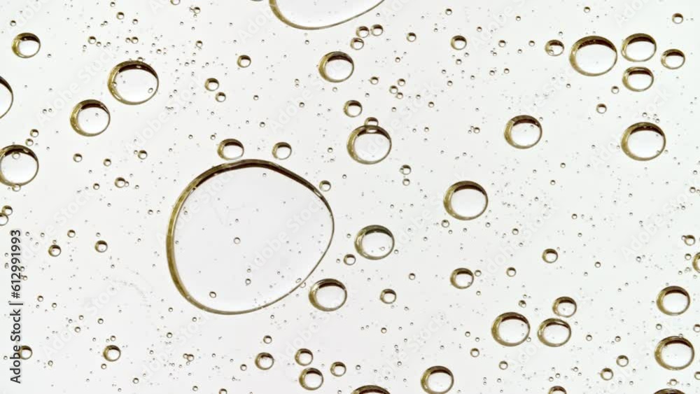 Transparent Cosmetic Gel Fluid With Molecule Bubbles and Oil Distribution on a White Background. Macro Shot of Natural Organic Cosmetics, Medicine. Production Close-up. Slow Motion. Transparent Cosmetic Gel Fluid With Molecule Bubbles and Oil Distribution on a White Background. Macro Shot of Natural Organic Cosmetics, Medicine. Production Close-up. Slow Motion.