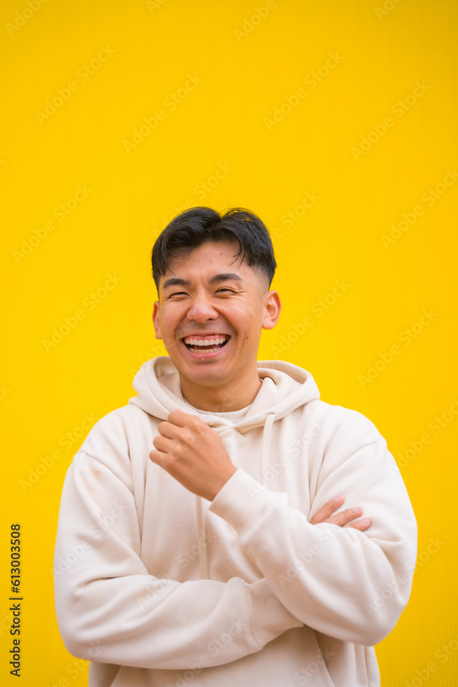 Portrait of a handsome South Korean Asian man in basic clothes smiling isolated over yellow background, smiling and having fun Portrait of a handsome South Korean Asian man in basic clothes smiling isolated over yellow background, smiling and having fun