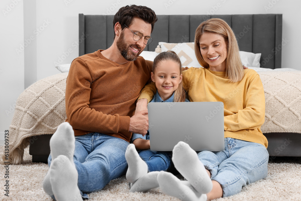 Happy family with laptop on floor at home Happy family with laptop on floor at home