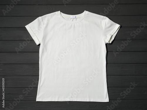 Stylish white T-shirt on gray wooden table, top view