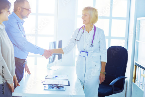 Female doctor handshaking a patient's hand and smiling