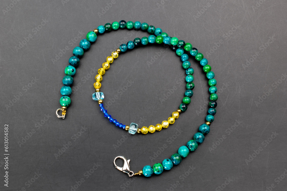 Colorful gemstone crystal beads necklace on black, unique handmade jewelry background, promotional photo for an online jewelry store Colorful gemstone crystal beads necklace on black, unique handmade jewelry background, promotional photo for an online jewelry store