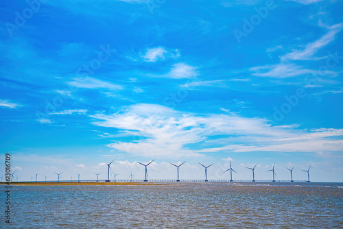 Panoramic view of wind farm at sea, with high wind turbines for generation electricity with copy space at Tra Vinh, Viet Nam. Green energy concept. Eco concpept photo