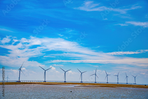 Panoramic view of wind farm at sea, with high wind turbines for generation electricity with copy space at Tra Vinh, Viet Nam. Green energy concept. Eco concpept photo