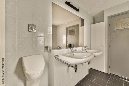 a bathroom with a white toilet and black tile floor in the photo is taken to the right  there is a mirror on the