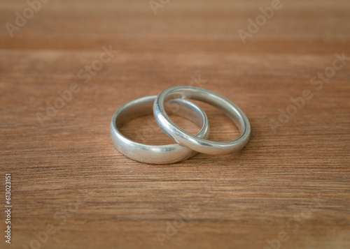 Wedding band rings on wood surface isolated. White gold metal. Copy space.