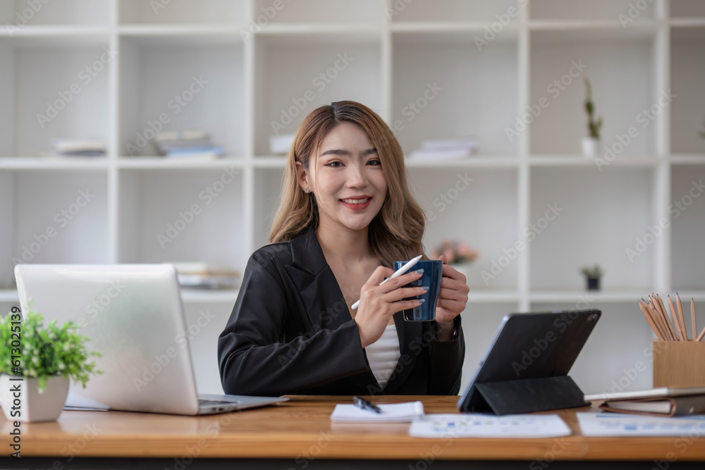 Asian Business woman using calculator and laptop for doing math finance on an office desk, tax, report, accounting, statistics, and analytical research concept Asian Business woman using calculator and laptop for doing math finance on an office desk, tax, report, accounting, statistics, and analytical research concept