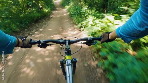 A man rides a bicycle at high speed down a dirt forest road. Stops in front of a puddle. First person view. POV. Outdoor cycling
