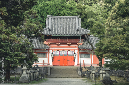 A small traditional Japanese shrine stands in quiet reverence, nestled amidst nature's embrace.